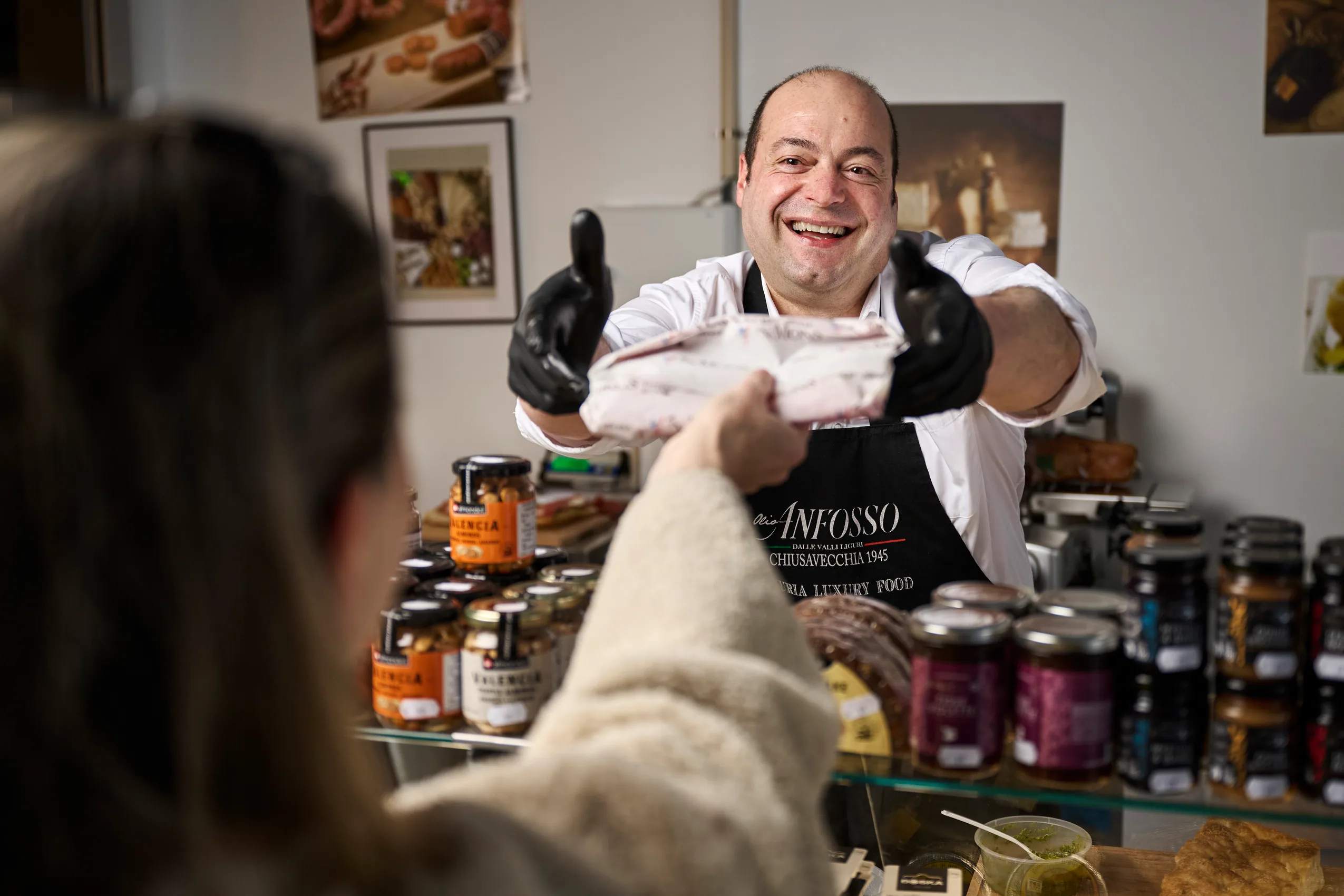 Patrick rekker fram en pakke til en kunde